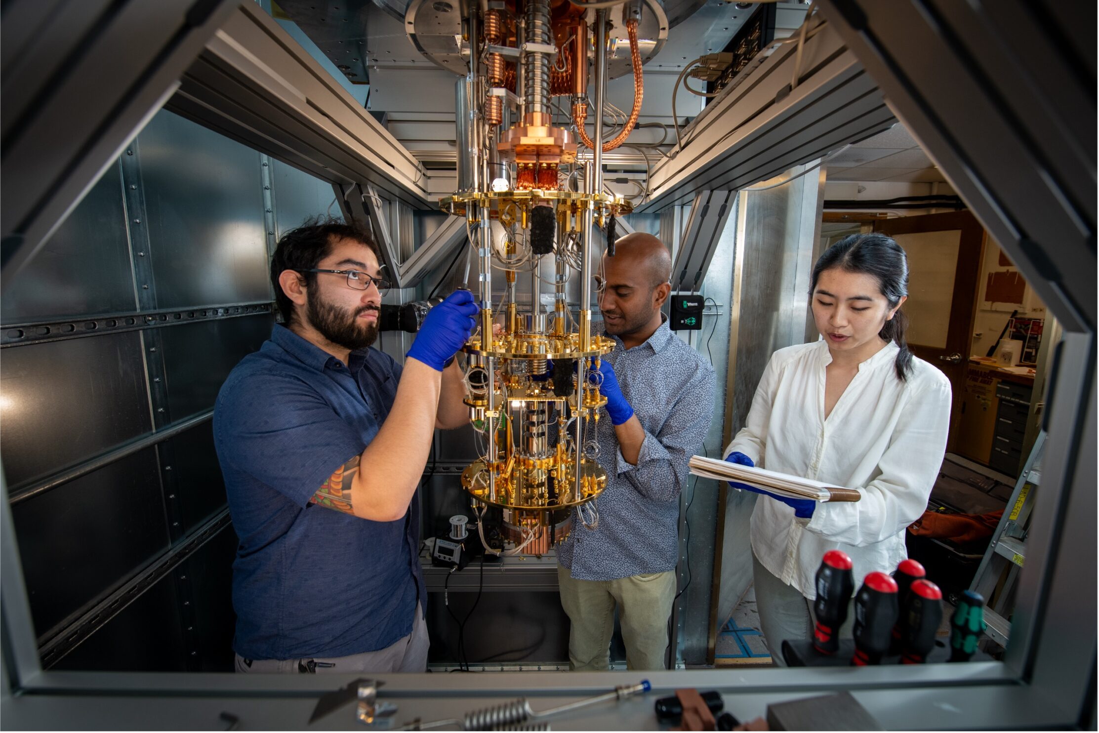 Michael Williams (left), Graduate Student Research Associate, Physics Division, Vetri Velan, Postdoctoral Researcher, Physics Division, and Yue Wang, Graduate Student Research Associate, Physics Division, work on HeRALD, a Helium Rotor Apparatus utilized as a detector for Light Dark Matter, at the Xenon Lab in Building 50 at Lawrence Berkeley National Laboratory (Berkeley Lab)